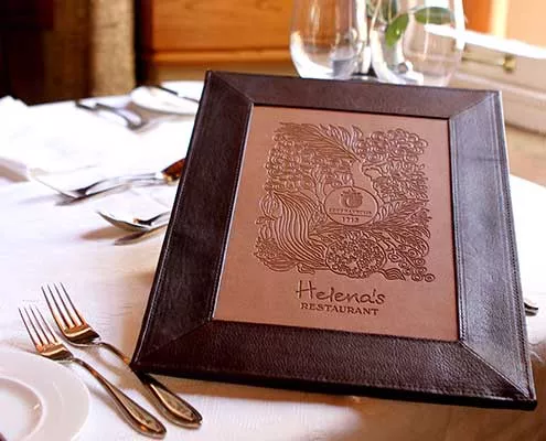 Helena's leather-bound menu on a white tablecloth